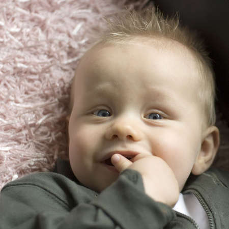 a cute baby with his finger in his mouth
