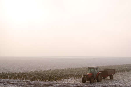 a tractor on a farmland in the winterの写真素材
