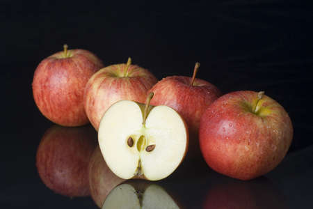 for whole apples in a row, with a half apple in the frontの写真素材