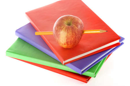 a pile of books with an apple and a pencil