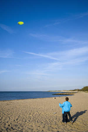two boys are kiting with there yello kiteの写真素材