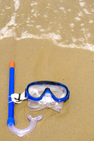 a mask on the beach, near the water of the oceanの写真素材