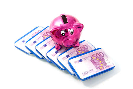 a pink piggybank with chocolate banknotesの写真素材