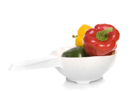 a colander with three healthy paprikas on whiteの写真素材