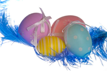 four colorful easter eggs  with a blue featherの写真素材