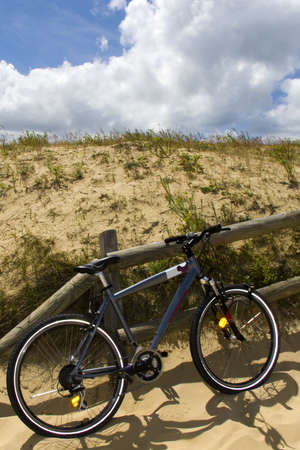 a bike parked at a fence by the dunesの写真素材