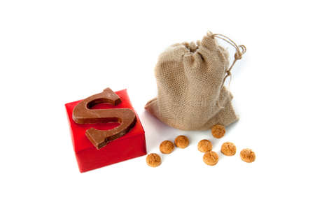 A jute bag full of pepernoten, a present and a chocolate letter, for celebrating a dutch holiday " Sinterklaas "  on the fifth of Decemberの写真素材