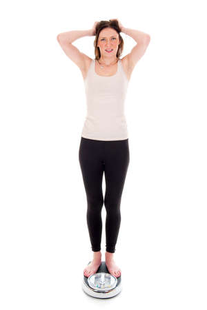 a girl on a weighing scale, celebrating her success of loosing weightの写真素材