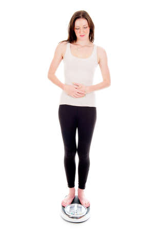 a girl on a weighing scale, celebrating her success of loosing weightの写真素材