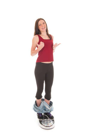 a girl on a weighing scale, celebrating her success of loosing weightの写真素材