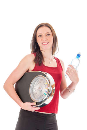 a girl with a weighing scale and a bottle of water,  celebrating her success of loosing weightの写真素材