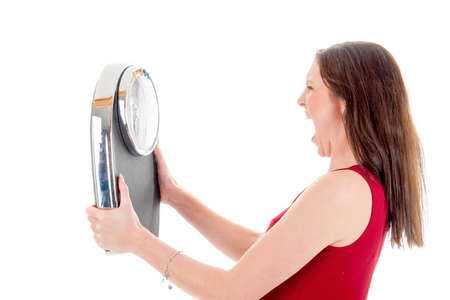 an angry girl with a weighing scale, on a white backgroundの写真素材