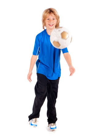 a young boy, playing football on a white backgroundの写真素材