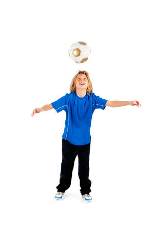 Portrait of a young soccer player heading ball isolated over white backgroundの写真素材