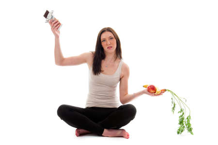 a girl on a diet, choose chocolate instead of vegetables and fruitの写真素材