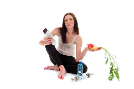 a girl on a diet, with a chocolate and fruit and vegetablesの写真素材
