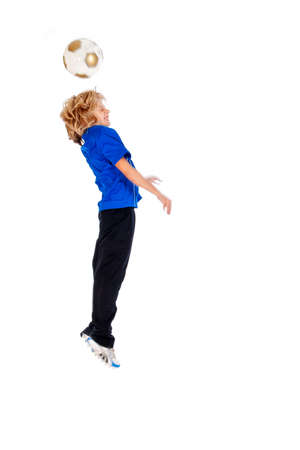 Portrait of a young soccer player heading ball isolated over white backgroundの写真素材