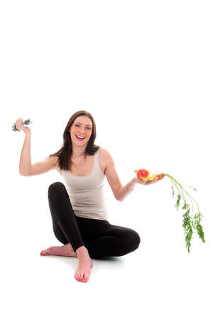 a girl on a diet, with a dumbbell and fruit and vegetablesの写真素材