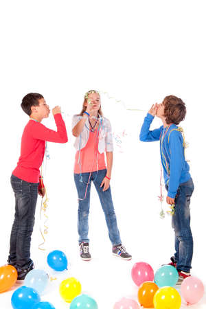 a birthday girl with her two friends and balloons on a white backgroundの写真素材