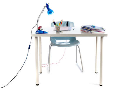a desk for a teenager to make homework. Desk with books, exercise books, lamp; pen, pencils and a chair.の写真素材