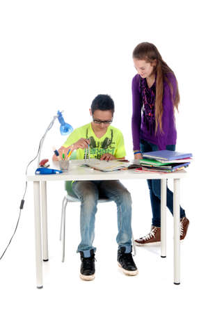 A teenage girl is helping a teenage boy with his math homework.の写真素材