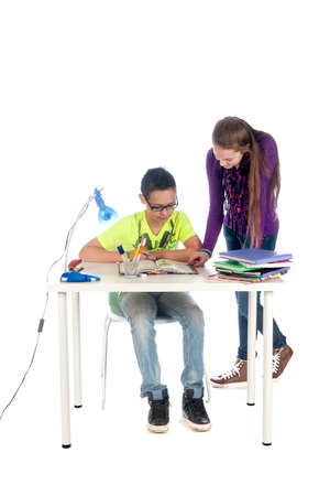 A teenage girl is helping a teenage boy with his homeworkの写真素材