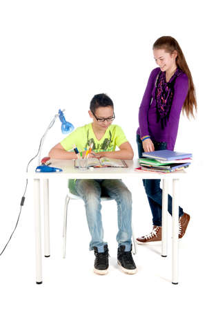 A teenage girl is helping a teenage boy with his homeworkの写真素材
