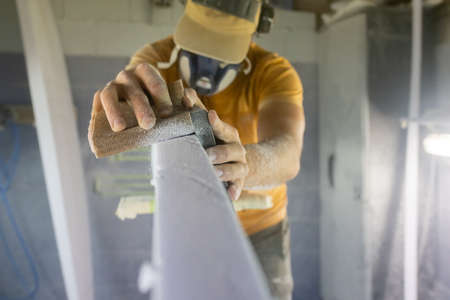 Master surfboard shaper sanding a new surfboard, skilled craftsman carefully crafting a new designの写真素材