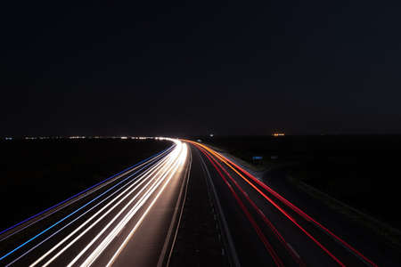 Highway car trails curve nightの写真素材