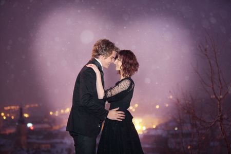 Profile of Romantic Couple smiling looking into each others eyes against the city at night on valentine's dayの写真素材