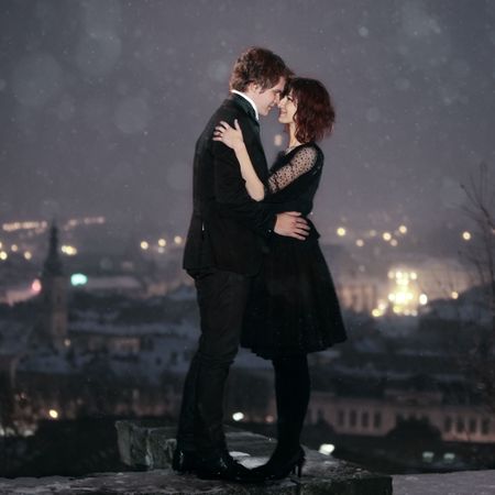 Full length profile of Romantic Couple looking into each others eyes against the city at night on valentine's dayの写真素材