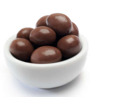 hazelnuts chocolate in bowl, white backgroundの写真素材