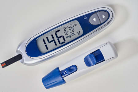 diabetes, glucometer with glucose measurement on screen and blood on test strip
