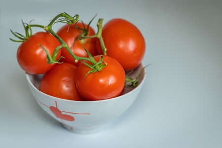 Ripe, red tomatoes in the kitchen in a bowlの写真素材