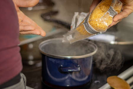 A man puts pasta in the brothの写真素材