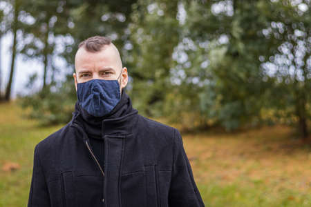 A man in a mask stands in the parkの写真素材