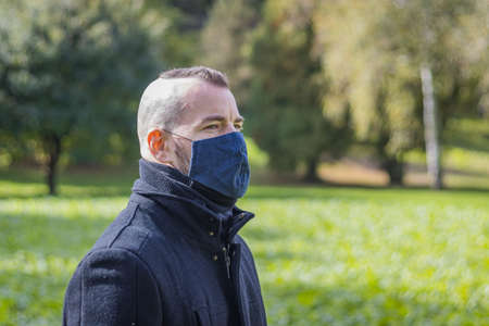 A man stands in a local park in a maskの写真素材