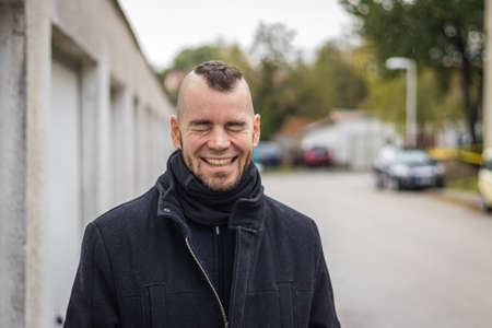 A man stands in front of garages in a small city in Hungaryの写真素材