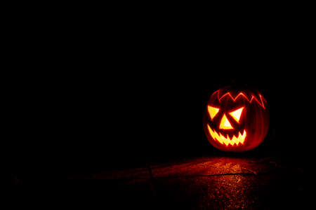 Spooky Halloween pumpkin lantern at night in the darknessの写真素材