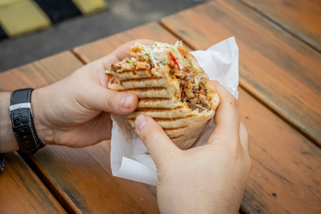 A man eats Doner Kebab at a local street food stallの写真素材
