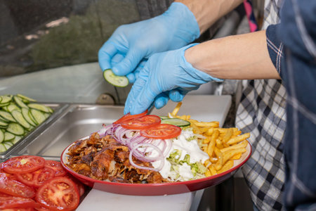 Doner kebab or gyros on a plate with french fries is prepared in the restaurantの写真素材