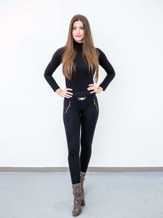 Smiling beautiful young woman standing over white wallの写真素材