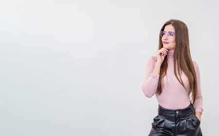 Beautiful young smiling woman with glasses standing over white wallの写真素材