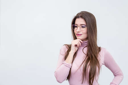 Beautiful young smiling woman with glasses standing over white wallの写真素材