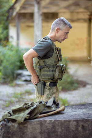 A man preparing for the airsoft game in an abandoned hangar in military uniformの写真素材