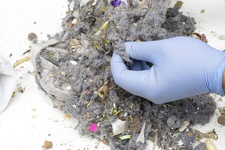 Searching with gloves in household wasteの写真素材