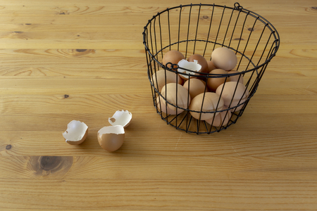 Chicken eggs in basket on wooden background
