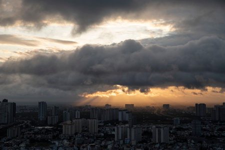 A city skyline with a cloudy sky in the background. The sky is dark and the sun is setting