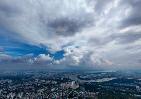A city with a river running through it. The sky is cloudy and the sun is not visibleの写真素材