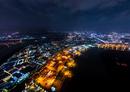 A city at night with lights on. The city is lit up with many lights. The sky is cloudyの写真素材